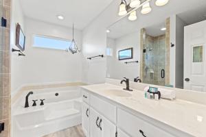 Baño blanco con lavabo, bañera y espejo en Vacation in This Gorgeous 2-Story Home! 3 BR 3 BA! Sleeps 8!, en Sunnyside 39 fotos más