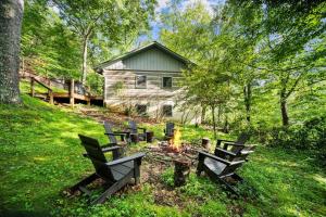 eine Gruppe von Bänken um ein Feuer vor einer Hütte in der Unterkunft Riverdale in Boone