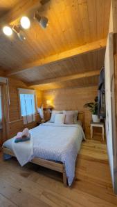 une chambre avec un lit dans une cabane en rondins dans l'établissement Chalet avec salle d'eau, à Chavagne
