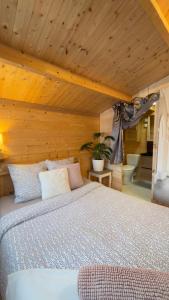 une chambre avec un lit et un plafond en bois dans l'établissement Chalet avec salle d'eau, à Chavagne