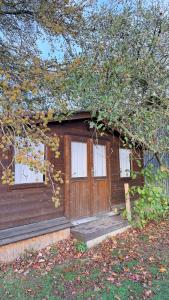 une petite maison avec trois fenêtres et un arbre dans l'établissement Chalet avec salle d'eau, à Chavagne 12 autres photos