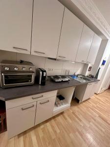 a kitchen with white cabinets and a black counter top at Nest76 in Karlsruhe