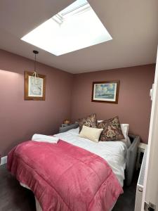 a bedroom with a large bed with a red blanket at The riverside place in Newry