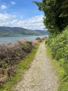 a dirt road next to a body of water at The riverside place in Newry