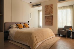 a bedroom with a large bed and a chair at Brassbell Zamalek Diplomatic Zone Near Marriott in Cairo