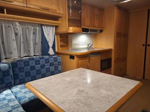 a kitchen with a table and chairs in a room at Proboost Arctic Center Cosy Caravan in Rovaniemi