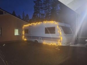 a white rv parked in a garage with lights at Proboost Arctic Center Cosy Caravan in Rovaniemi