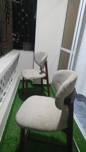 Dos sillas sentadas una al lado de la otra en un balcón. en EL Nido, en Mombasa