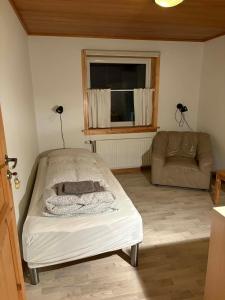 une chambre avec un lit, un canapé et une fenêtre dans l'établissement Midbrekkan Guesthouse, à Tvøroyri