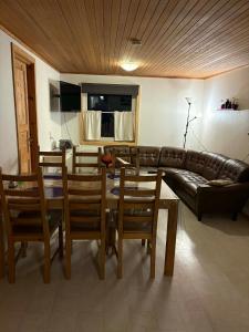 un salon avec un canapé, une table et des chaises dans l'établissement Midbrekkan Guesthouse, à Tvøroyri 1 autre photo