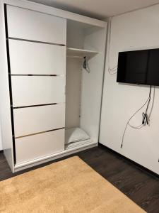 a closet with a tv and a white wall at Apartamente B&K in Râşnov