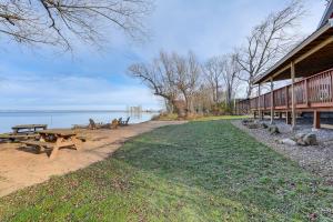 a picnic table and benches next to the water at Spacious Family Winter Retreat on Oneida Lake! in Canastota