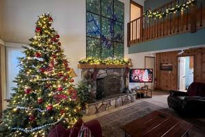 un árbol de Navidad en una sala de estar con chimenea en Waterfront Gem on Lake Martin with Kayaks and Dock!, en Eclectic