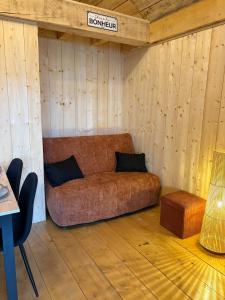- un canapé dans une chambre dotée de murs en bois dans l'établissement La Cabane de Sophie - Nature et Calme, à Saint-Cernin 9 autres photos