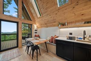 a kitchen with a table and chairs in a cabin at Ascent A-Frame at Calm Ridge Treehouses in Boone