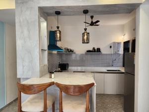 cocina con mesa y 2 sillas en Calm 1BHK Modern Apartment in Candolim with Pool, Balcony & Modern Decor, en Candolim