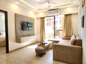 Una sala de estar con un sofá y una ventana grande. en Calm 1BHK Modern Apartment in Candolim with Pool, Balcony & Modern Decor, en Candolim