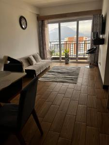 un soggiorno con un divano e una grande finestra di Luxury living Sarabela Altos de Occidente, Interplaza Xela a Quetzaltenango