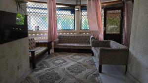 Zimmer mit Sofas und Fenstern in einem Gebäude in der Unterkunft Kivuli Holiday Homes Limited in Galu