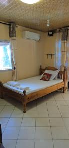 - un lit en bois dans une chambre avec fenêtre dans l'établissement Kivuli Holiday Homes Limited, à Galu