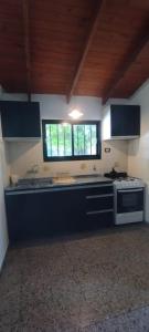 eine große Küche mit Herd und Fenster in der Unterkunft La Casa de Elisa in Santa Rosa de Calamuchita