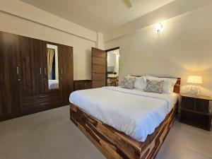 Serene 1BHK Getaway Apartment in Candolim Goa with Pool, Balcony & Kitchen في كاندوليم: غرفة نوم بسرير كبير مع ملاءات بيضاء +36 صورة