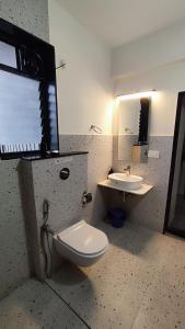 Serene 1BHK Getaway Apartment in Candolim Goa with Pool, Balcony & Kitchen في كاندوليم: حمام مع مرحاض ومغسلة