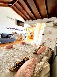 a large couch with pillows on it in a living room at Rinconcito Rural con encanto en Las Hayas by Vapagó Tenerife in Acardece