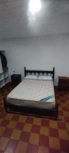 Bett in einem Zimmer mit einem karierten Boden in der Unterkunft La Casa de Elisa in Santa Rosa de Calamuchita + 10 Fotos