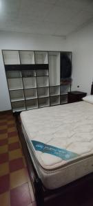 Bett in einem Zimmer mit einem TV an der Wand in der Unterkunft La Casa de Elisa in Santa Rosa de Calamuchita