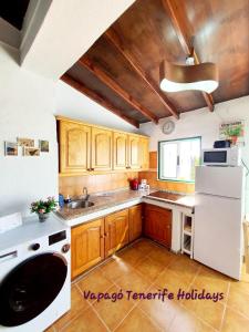 a kitchen with wooden cabinets and a white refrigerator at Rinconcito Rural con encanto en Las Hayas by Vapagó Tenerife in Acardece