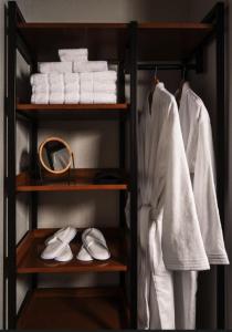 韦恩堡The Amaya - 21 and older only的衣柜里放着毛巾和鞋子的架子