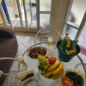 Ein Tisch mit einem Haufen Obst und Gemüse drauf. in der Unterkunft Casa em Caraguá, uma quadra da praia com ar in Caraguatatuba