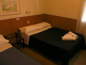 a room with two beds with towels on a table at Hotel Hawai in Villa Carlos Paz
