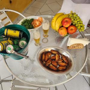 ein Tisch mit einer Schüssel mit Essen, Früchten und Getränken in der Unterkunft Casa em Caraguá, uma quadra da praia com ar in Caraguatatuba