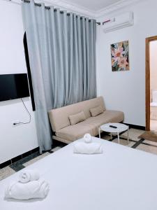 Una sala de estar con un sofá y un televisor en Hotel La Casa Blanca, en Tetuán