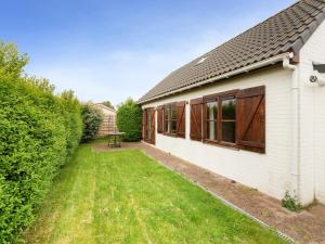 a house with a yard next to a building at Zeepark Haerendycke - Vakantiewoning 40 in De Haan