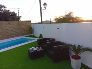 un patio avec une table et des chaises et une piscine dans l'établissement O Caminho Azul, à Olivenza