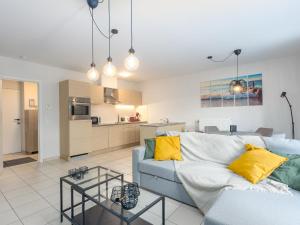 Una sala de estar con un sofá azul y una cocina. en Virgo - 0001, en Ostende