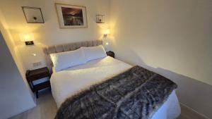 een slaapkamer met een bed met een deken erop bij Modern 1 bedroom riverside apartment in Ayr