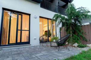 two chairs sitting on a patio in front of a house at Anur Apartment II in Ptuj