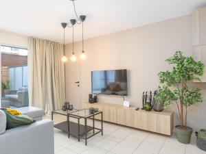 Una sala de estar con un sofá y un televisor en Virgo - 0001, en Ostende