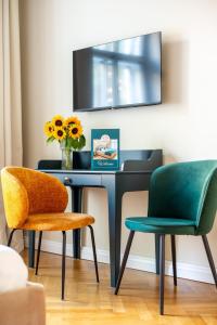 ein Schreibtisch mit zwei Stühlen und einer Vase mit Blumen in der Unterkunft Little Heaven Apartments in Sibiu
