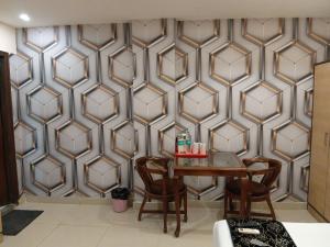 加姆布Airport Hotel The Paramont Palace Inn New Delhi的墙上有桌椅的房间 更多30张照片