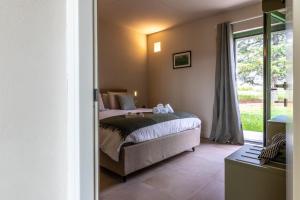 列蒂Nicolò e gli alberi Villino C的一间卧室，里面有一张床和一扇大窗户。