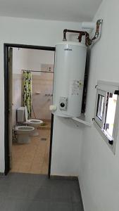 ein Bad mit einem WC, einem Fenster und einem Spiegel in der Unterkunft La Casa de Elisa in Santa Rosa de Calamuchita