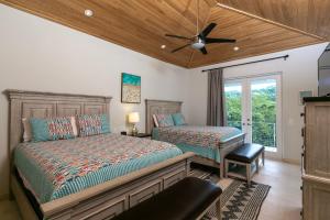 a bedroom with two beds and a ceiling fan at Pirates Villa- Beach view with kayaks for Groups in Cruz Bay