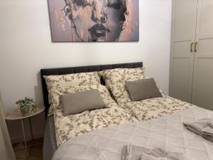 a bed with a blanket and two pillows on it at W275 Apartment in Pruszków +3 photos