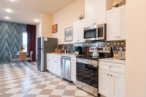 a kitchen with white cabinets and a checkered floor at The Francesca - Apt 332 in Bryan