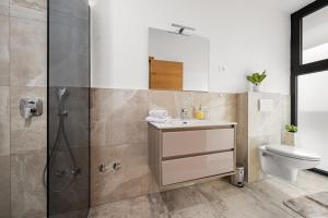 ein Badezimmer mit Dusche, Waschbecken und Toilette in der Unterkunft Santalezi Sunset Villa 2 in Santalezi + 9 Fotos